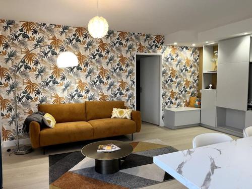 a living room with a couch and a flowery wall at La Villa du Soleil in Saint-Cyprien