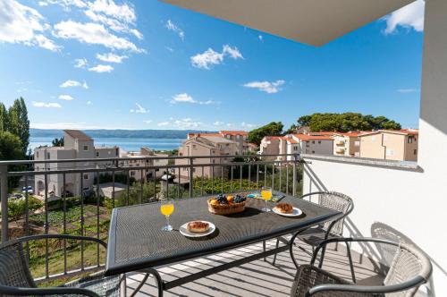 a table and chairs on a balcony with a view at Apartments and Rooms Nikola in Omiš