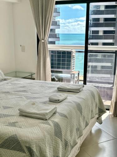a bedroom with a bed and a view of the ocean at Landscape Diamond 1409 in Fortaleza