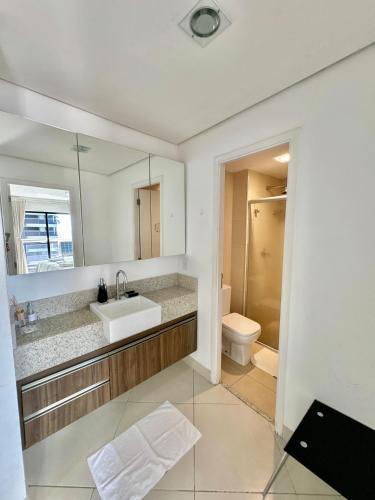 a bathroom with a sink and a toilet and a mirror at Landscape Diamond 1409 in Fortaleza