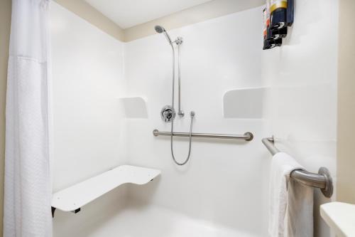 a bathroom with a shower with a white shower curtain at Beachside Resort Panama City Beach in Panama City Beach