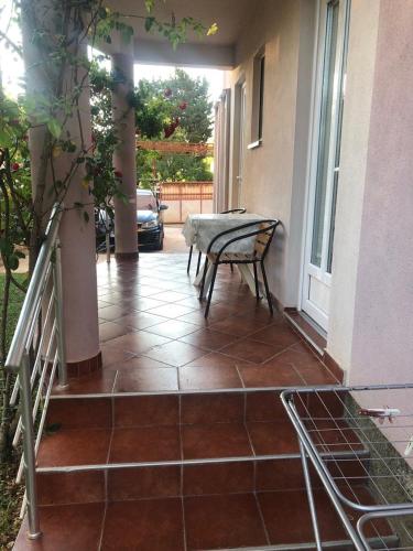 a patio with a bench sitting on a porch at Apartmani Milanovic Susanj in Bar