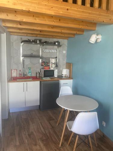 una cucina con un tavolo e sedie in una stanza di Love Tiny House a Faro