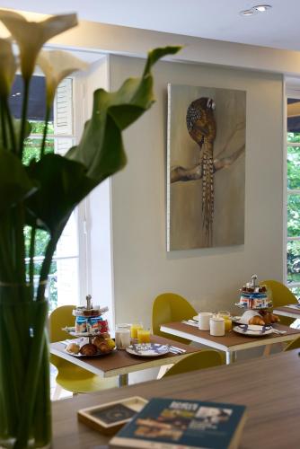 a table with a picture of a skeleton on the wall at Logis Hôtel Marguerite in Orléans