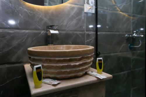 a bathroom with a large stone sink and two glasses at Crowne Pyramids View inn in Cairo