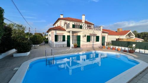 a swimming pool in front of a house at Casa vista Arrabida in Cotovia
