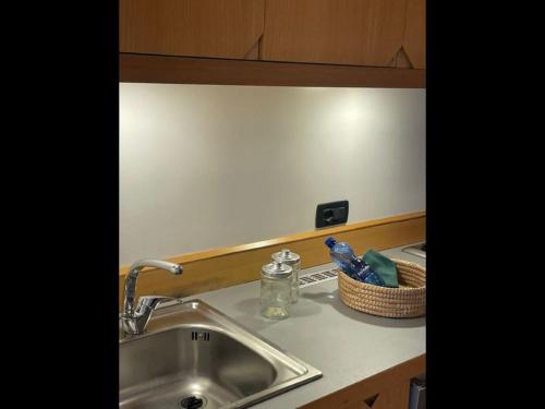 a kitchen counter with a sink and a basket of toothbrushes at garibaldi citta' in Trapani