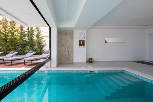a swimming pool in a house with a large window at Villa Luna Mare mit Pool und Sauna in Podaca