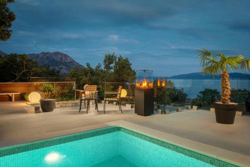 a patio with a swimming pool and a table and chairs at Villa Luna Mare mit Pool und Sauna in Podaca