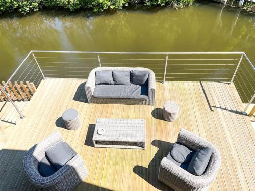 a wooden deck with couches and chairs on a boat at Moulin de Chenappé in Neuilly-le-Bisson