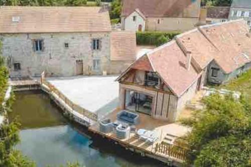 an aerial view of a house with a dock in the water at Moulin de Chenappé in Neuilly-le-Bisson