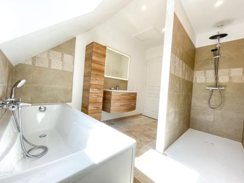 a bathroom with a white tub and a sink at Moulin de Chenappé in Neuilly-le-Bisson