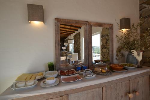 een buffet met eten op een aanrecht met een spiegel bij Casa dos Castelejos in Guerreiro
