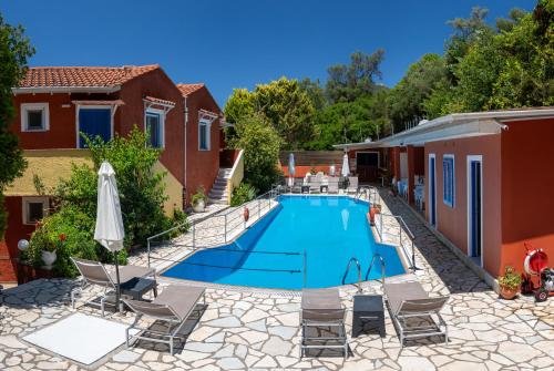 a swimming pool in a backyard with chairs and an umbrella at Vliho Bay Boutique Hotel in Yenion