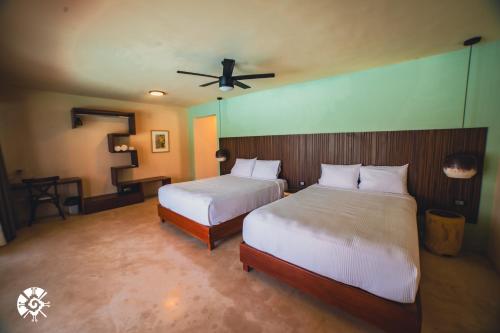 a bedroom with two beds and a ceiling fan at Hacienda Susulá in Susulá