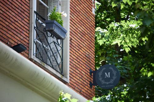 a window with a sign on the side of a building at Logis Hôtel Marguerite in Orléans