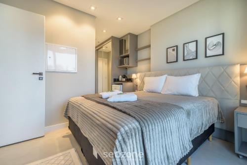 a bedroom with a bed with two towels on it at MHFA - Studios em Prédio Luxuoso com Vista Mar in Itapema