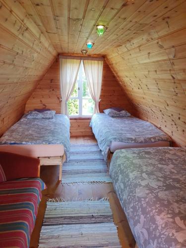 a room with three beds in a log cabin at Kadariku Tourism Farm in Sakla
