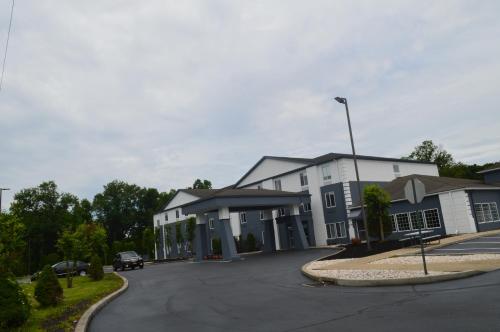 a white building with a car parked in a parking lot at Comfort Inn & Suites Harrisburg-Hershey North in Harrisburg