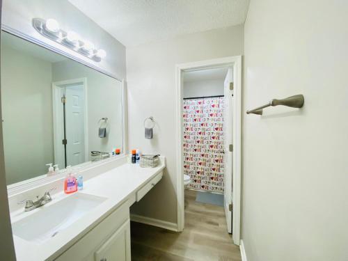 a bathroom with a sink and a large mirror at Spacious room with Shared bathroom in Raleigh