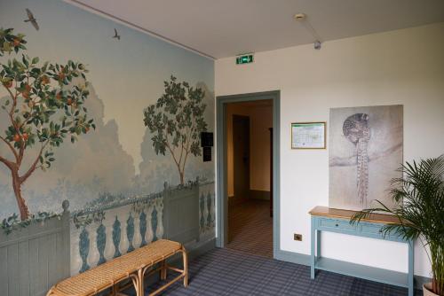 a hallway with a mural of trees on the wall at Logis Hôtel Marguerite in Orléans
