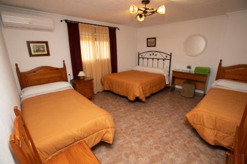 a hotel room with two beds and a window at El Olmo in Posadas