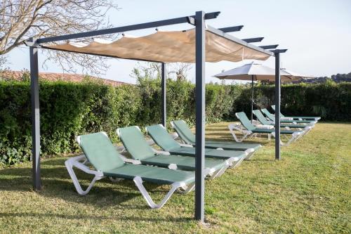 a row of lounge chairs under an umbrella at El Olmo in Posadas