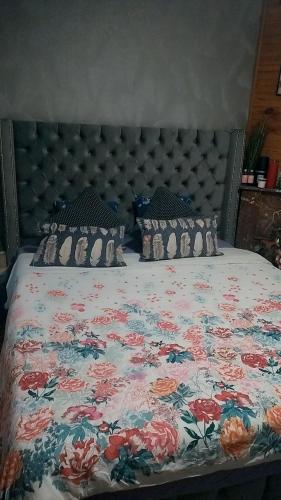 - un lit avec un couvre-lit floral et des oreillers dans l'établissement Appartement, à Aubervilliers