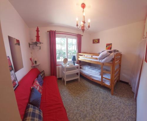 une chambre avec deux lits superposés et une fenêtre dans l'établissement La Sirène Escapade en famille ou entre amis Maison lumineuse avec extérieur privé à 5 min de la plage Confort et convivialité assurés, à Saint-Trojan-les-Bains