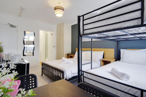 a bedroom with two bunk beds and a table at Bonnington Beach in Bournemouth