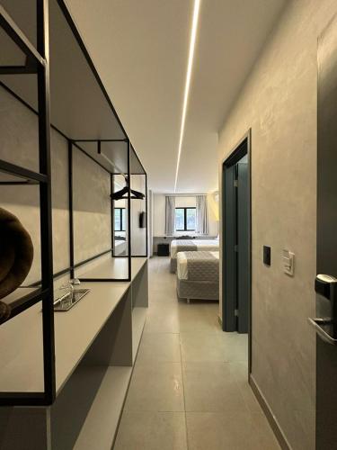 a room with a bed and a room with a mirror at 232 Concept Hotel in Caruaru