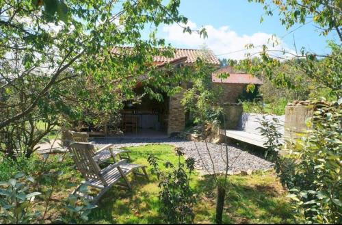 a garden with a bench and a house at Le Poulailler in Blesle