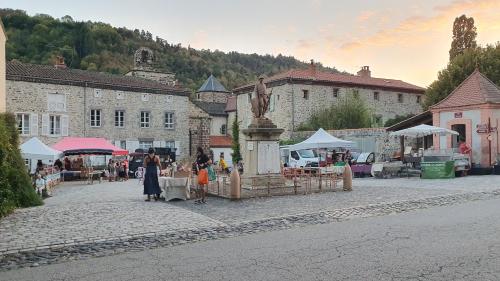 a group of people walking around a market with a statue at Le Poulailler in Blesle