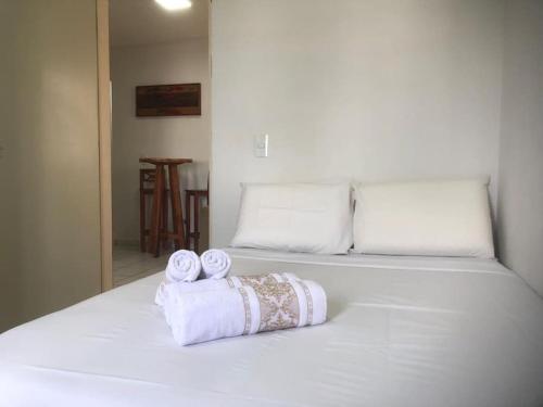a white bed with two rolls of towels on it at Apartamento climatizado in Marília