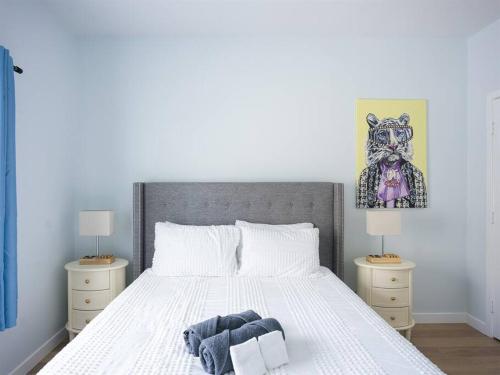 a bedroom with a white bed with two night stands at Family Renovated Home, Netflix, AC, WD, Putt Putt in Fullerton