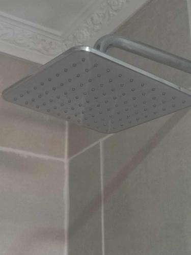 a metal shower rack on the ceiling of a bathroom at Serene Cottage in Francistown