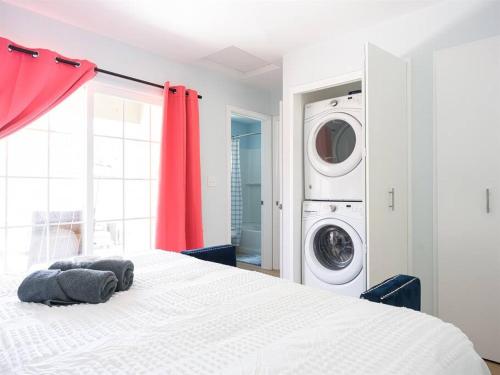 a white bed in a room with a washing machine at Family Renovated Home, Netflix, AC, WD, Putt Putt in Fullerton