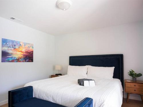 a bedroom with a large bed with a blue chair at Family Renovated Home, Netflix, AC, WD, Putt Putt in Fullerton