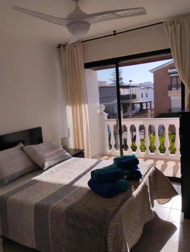 a bedroom with a bed with two blue towels on it at Villa Jade Beach in Cala del Moral
