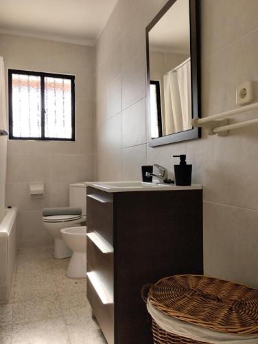 a bathroom with a sink and a toilet and a mirror at Villa Jade Beach in Cala del Moral