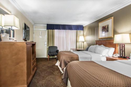 a hotel room with two beds and a television at Quality Inn Morgan City in Morgan City