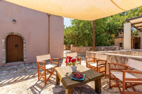 a patio with a table and chairs and a door at Patitiri by Vintage Travel in Korakiaí