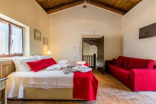 a bedroom with a bed and a red couch at Patitiri by Vintage Travel in Korakiaí