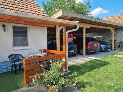 a wooden pergola with cars parked in a driveway at Napfény Apartman in Bogács