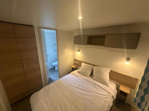 une chambre avec un lit blanc et une salle de bain dans l'établissement Cottage Domaine Privé - Sud de France - Jacuzzi, à Le Cailar