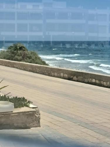a boardwalk with the ocean in the background at Adan Beach appartment in front of Atlantic in Aourir