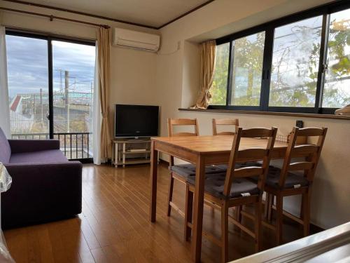 a living room with a table and chairs and a television at Rakuten Stay [Homelike Makuhari Hongo] - Vacation STAY 16003v in Chiba