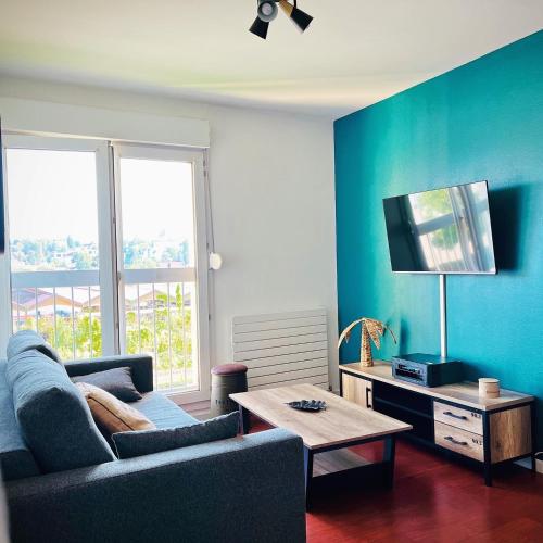 un salon avec un canapé et une table dans l'établissement Appartement tout confort avec Baby-foot, à Épinal