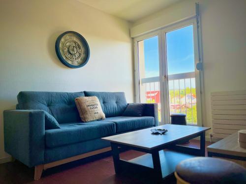 un salon avec un canapé bleu et une table dans l'établissement Appartement tout confort avec Baby-foot, à Épinal