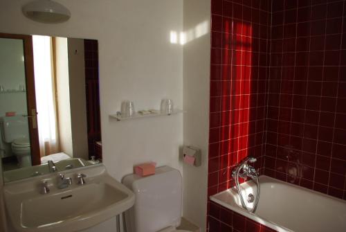 a bathroom with a sink and a toilet and red tiles at HOTEL Le TOURISME in Passy